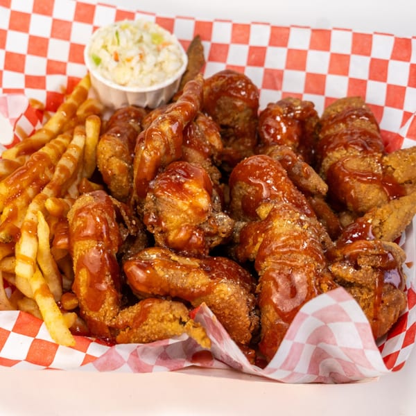 Crispy fried chicken wings drizzled with barbecue sauce, served with crinkle-cut fries and coleslaw.
